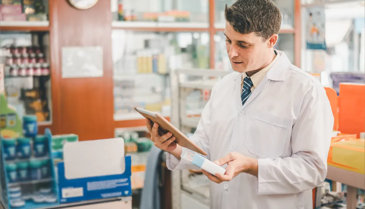 Pharmacy worker checking a generic medicine package with a tablet