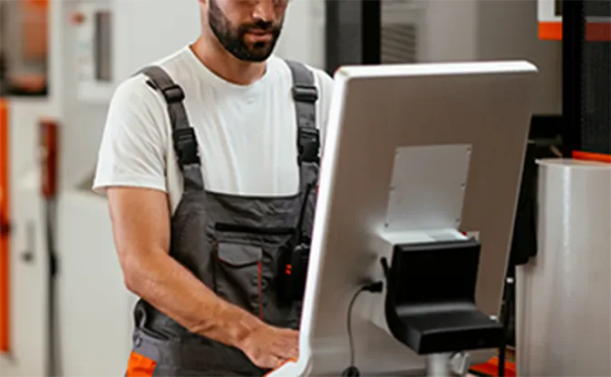 Technician working at an industrial station while reviewing equipment information