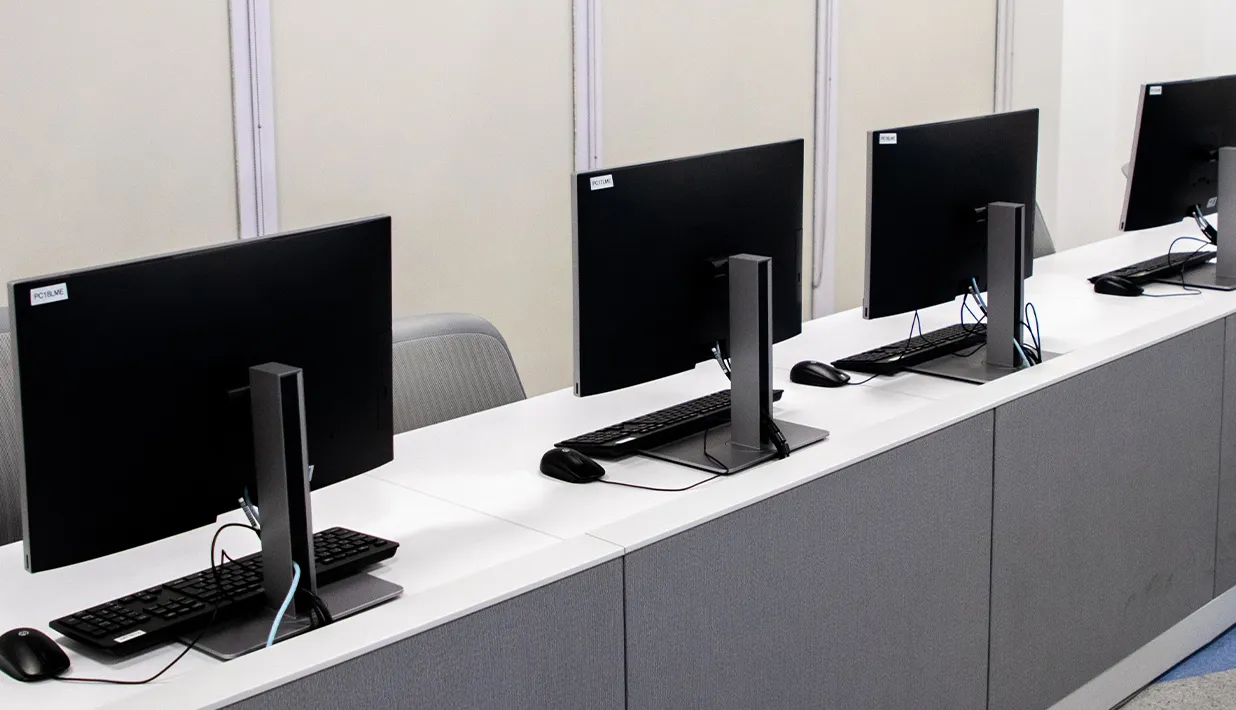 Row of desktop computers on work counters, illustrating shared equipment that can be tracked