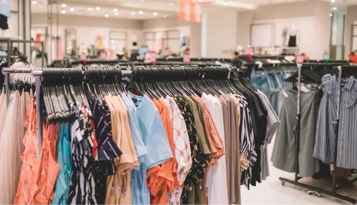 Rows of apparel on clothing racks in an illustrative retail store